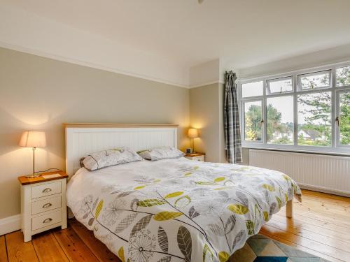 um quarto com uma cama grande e 2 janelas em 3 Bed in Sidmouth 78021 em Sidmouth