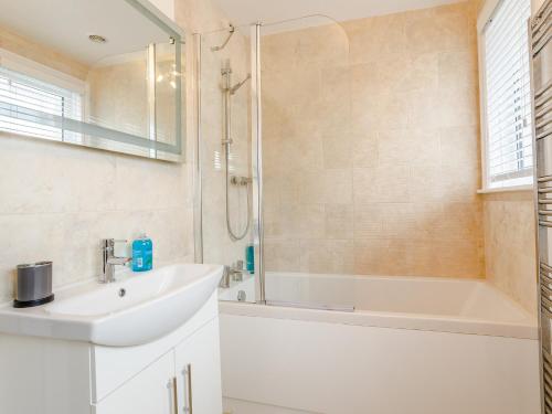 uma casa de banho com um lavatório, um chuveiro e uma banheira em 3 Bed in Sidmouth 78021 em Sidmouth