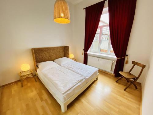 um quarto com uma cama, uma cadeira e uma janela em Riga em Warnemünde