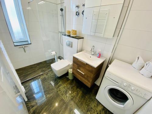 uma casa de banho com uma máquina de lavar roupa e um lavatório em Riga em Warnemünde