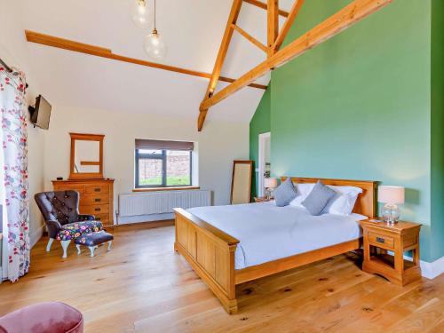 - une chambre avec un lit et un mur vert dans l'établissement 5 Bed in Ashbrittle 77900, 