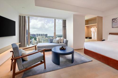 Habitación de hotel con cama y sofá en Doubletree By Hilton Shenzhen Airport Residences, en Shenzhen