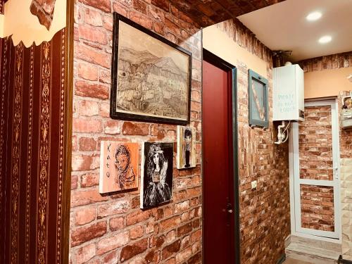 Una pared de ladrillo con fotos. en Lets Go House, en Tiflis