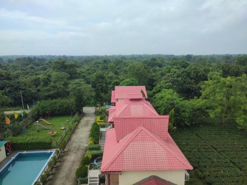 una vista aérea de una casa con techo rosa en Maa Greenary View - A Holiday Resort, en Alīpur Duār