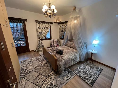 een slaapkamer met een bed en een kroonluchter bij AGAPI’S HOUSE in Metsovo