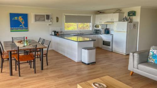 a kitchen and dining room with a table and a refrigerator at Island View 1 in Coffin Bay