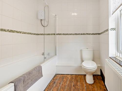 a white bathroom with a toilet and a tub at 2 Bed in Oswestry 76537 in Gobowen