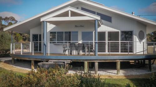 a large white house with a table and chairs at Rest A Shore Coffin Bay in Coffin Bay