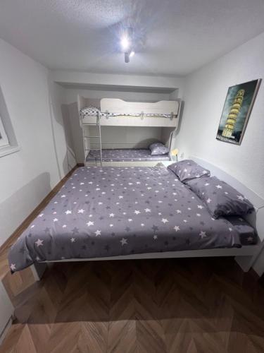a small bedroom with a bed with purple sheets at Mavrovo Square " Villas & Apartment " in Mavrovo