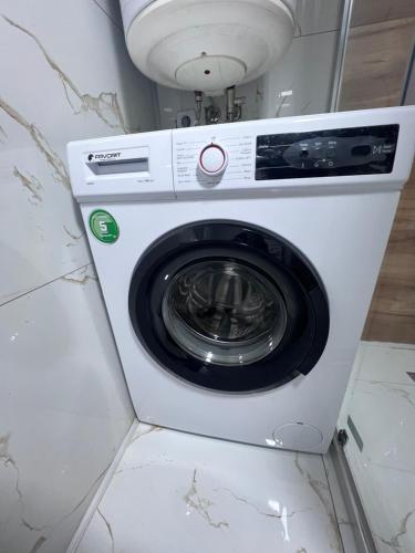 a white washing machine sitting in a room at Mavrovo Square " Villas & Apartment " in Mavrovo