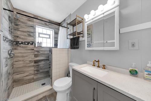a bathroom with a toilet and a shower and a sink at Route 66 Apt / 5min to HOSP & Metra train / 15min to MDW in Berwyn