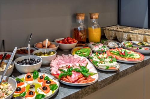 a buffet with many plates of food on a counter at Cotton House in Łódź