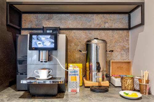 a coffee machine and a television on a counter at Cotton House in Łódź