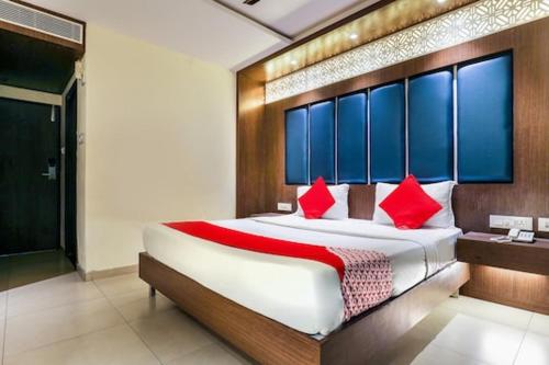 a bedroom with a large bed with red pillows at Hotel Sri Capital Residency in Vijayawāda