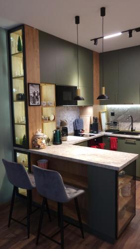 a kitchen with a large counter and two chairs at Pinewood ANG premium luxurious apartment 15 in Borovets