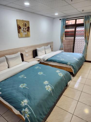 two beds in a room with blue blankets at Chihpen Hot Spring Hotel in Wenquan