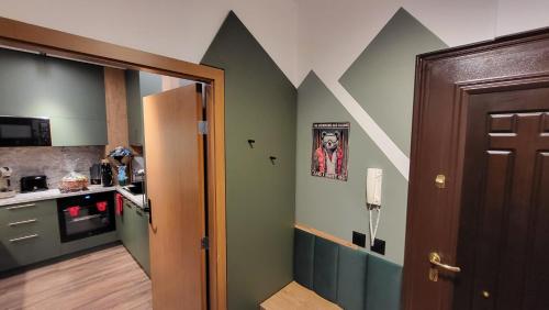 a kitchen with green walls with a picture of a man at Pinewood ANG premium luxurious apartment 15 in Borovets
