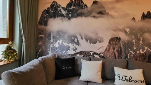 a couch in a living room with a mountain mural at Pinewood ANG premium luxurious apartment 15 in Borovets