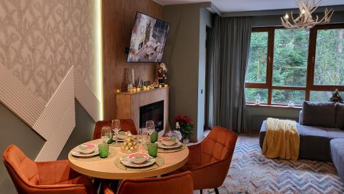a living room with a table and chairs and a couch at Pinewood ANG premium luxurious apartment 15 in Borovets