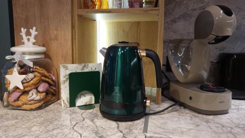 a greenffeepot sitting on a counter next to a blender at Pinewood ANG premium luxurious apartment 15 in Borovets