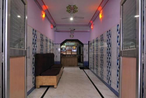 een gang met een bank in een kamer met paarse muren bij Hotel Prabhu Krupa, Bhubaneswar in Bhubaneshwar