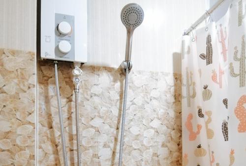 a shower with a shower head in a bathroom at RedDoorz @ Capitol View MC Inn Nueva Vizacaya in Bayombong