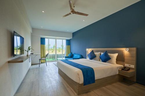 a bedroom with a large bed with a blue wall at Ikshana Resort and Spa, Khandala in Lonavala