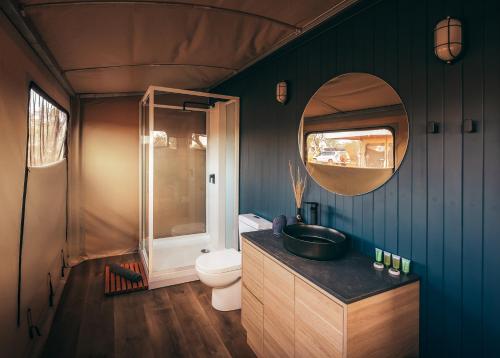 La salle de bains est pourvue de toilettes, d'un lavabo et d'un miroir. dans l'établissement Karijini Eco Retreat, à Karijini