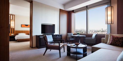 a living room with a couch and a room with a tv at Hyatt Regency Changchun in Changchun