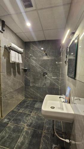 a bathroom with a sink and a shower at Emerald Urban Comforts in Mysore