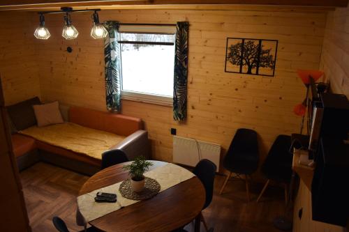 a living room with a table and a couch and a window at Domki Nad Potokiem in Tyrawa Wołoska