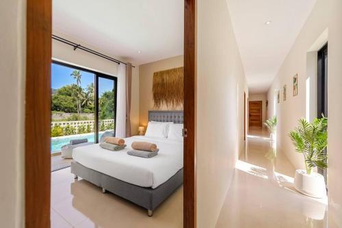 Schlafzimmer mit einem Bett und Poolblick in der Unterkunft Private Pool Paradise: Sereniwoods 3br in Nathon Bay