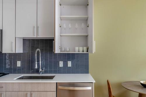 a kitchen with white cabinets and a sink and a table at South Boston 1br w gym nr red line shops BOS-984 in Boston