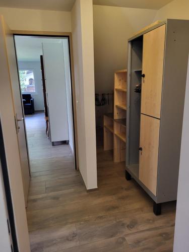 a hallway with an open door and a refrigerator at Splügen Haus Engadinella in Splügen