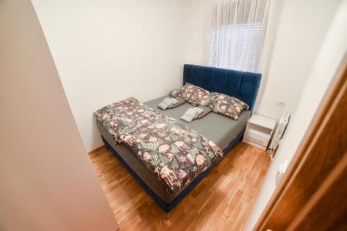 a bed in a room with a blue headboard and pillows at Apartman Ivkovic Zlatibor in Zlatibor