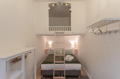 a staircase in a room with two beds and a mirror at La Blanche Hermine - Appartement centre de Rennes in Rennes