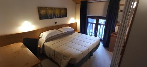 a bedroom with a bed in a room with a window at Hotel Alpechiara in Pré-Saint-Didier