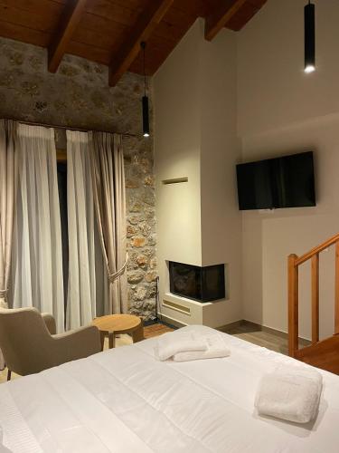 a bedroom with a white bed and a fireplace at Miltilon in Synikia Mesi Trikalon
