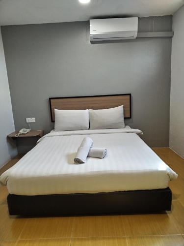 a bedroom with a bed with two towels on it at Maple Boutique Hotel Kota Bharu in Kota Bharu