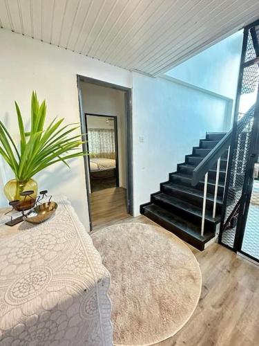 a living room with a table and a staircase at KK Sunset Villa- Full Sunset Balcony, Mosquito Free, 4K TVs, 5G WIFI and more! in Kota Kinabalu