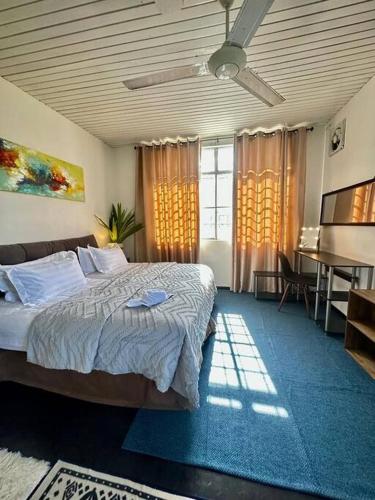 a bedroom with a bed and a desk in it at KK Sunset Villa- Full Sunset Balcony, Mosquito Free, 4K TVs, 5G WIFI and more! in Kota Kinabalu