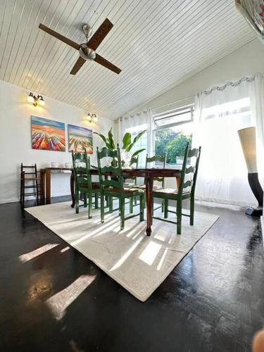 a dining room with a table and chairs and a ceiling fan at KK Sunset Villa- Full Sunset Balcony, Mosquito Free, 4K TVs, 5G WIFI and more! in Kota Kinabalu