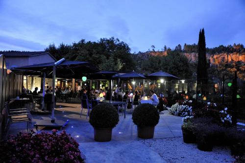 a group of people sitting at tables with umbrellas at Hostellerie Les Gorges De Pennafort in Callas