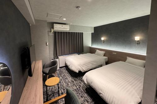 ニセコ町にあるニセコグランドホテルのベッド2台とデスクが備わるホテルルームです。