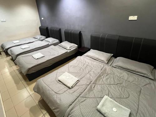 a room with three beds in a room at Pekan Budget Hotel in Pekan