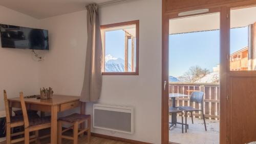 d'un salon avec une table et un balcon. dans l'établissement A1519 Etoiles D Orion- Studio 4 pers, à Orcières