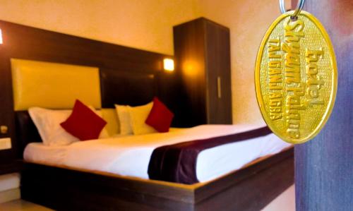 1 dormitorio con cama con almohadas rojas y espejo en HOTEL SHYAM PALACE INDIA AGRA en Agra