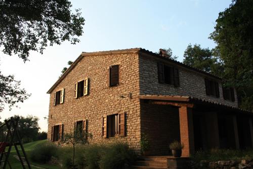 an old brick house with boarded up windows at Agriturismo Valdifiori in Sassoferrato