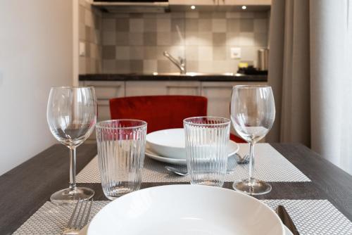 a table with four empty wine glasses on it at Motel-Résidence Ô Pied à Terre in Montilliez