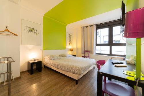 - une chambre avec un lit et un bureau dans l'établissement Maison Mondrian, à Mulhouse